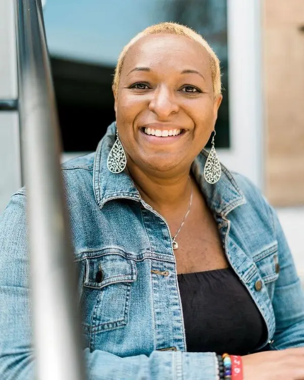 Korey Jenkins smiling casually with her Denim outfit