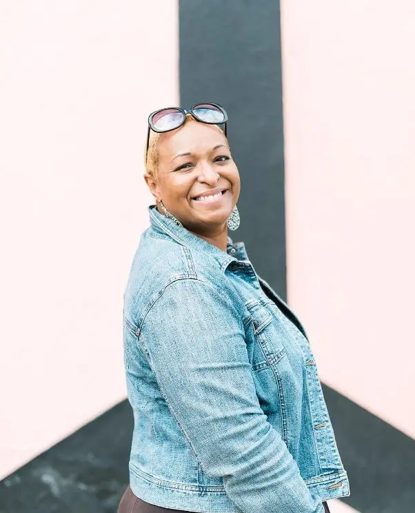 Korey Jenkins smiling casually with her Denim outfit